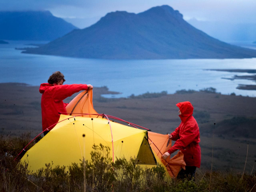 Two trampers setting up a One Planet tent in wild alpine conditions