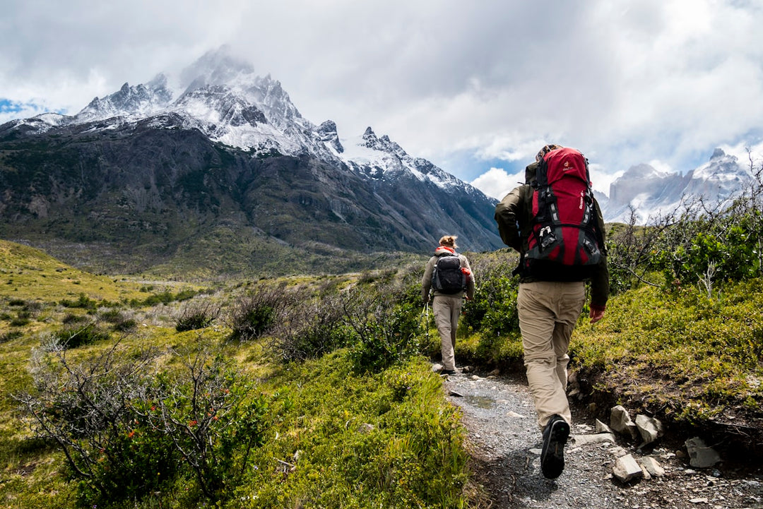 Two trampers on a mountain trail with large backpacks — NZ Great Walks gear list