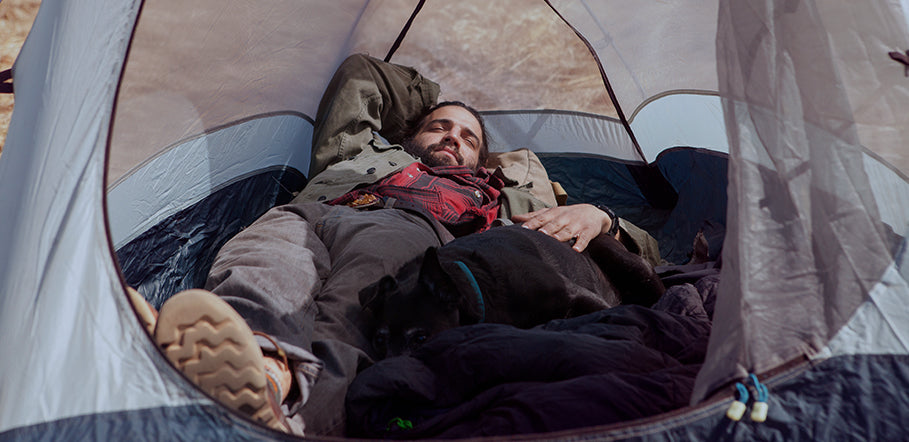 man asleep in a tent