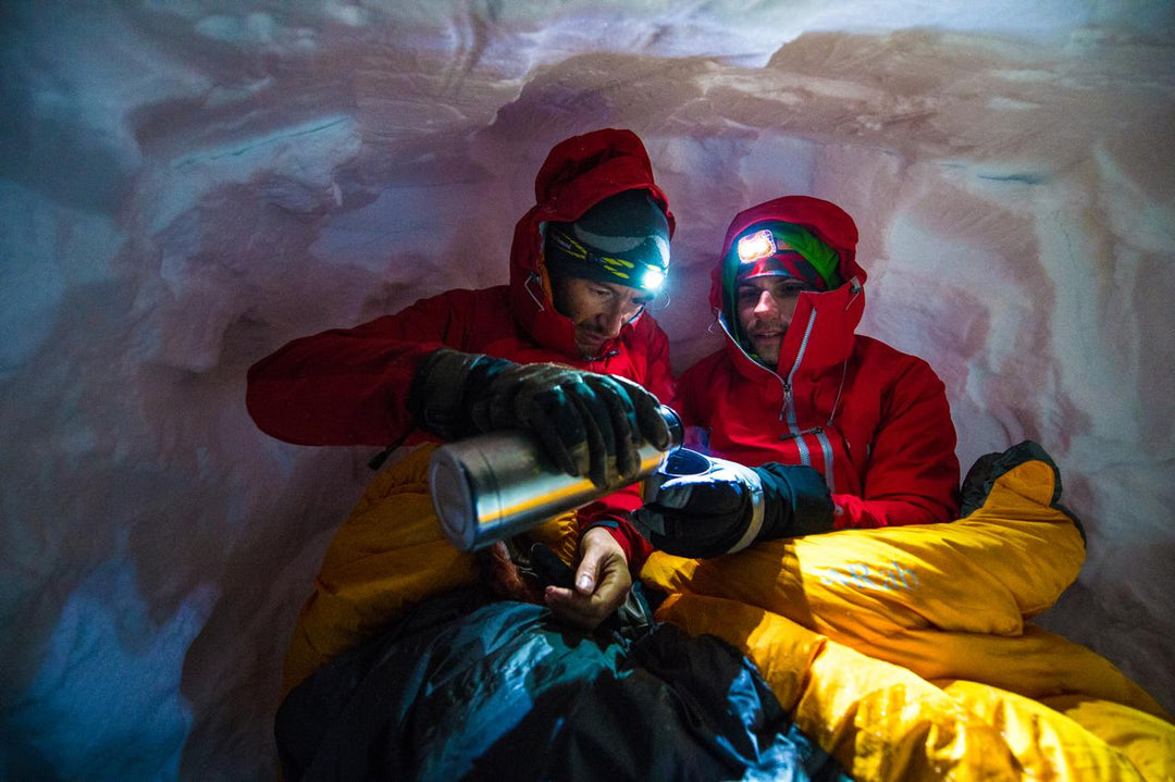 Two climbers in sleeping bags in a snow cave — Rab sleeping bags NZ