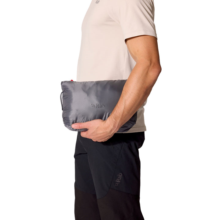 Rab Microlight Alpine Down Hoody packed into its integrated storage pocket and held at the hip.